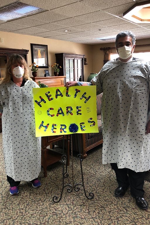 Jennifer Finnin, director of rehab services at Garden Terrace Aurora, with her homemade PPE and John Moreno, executive director
