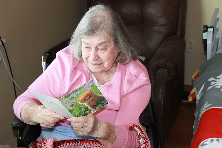 Resident Patricia White reading a card