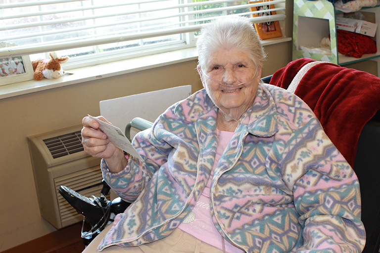 Resident Carol Thomas with a postcard