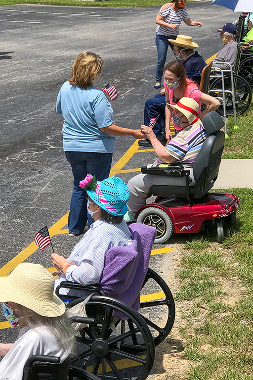 Candy Human, business office manager, handing out flags to residents