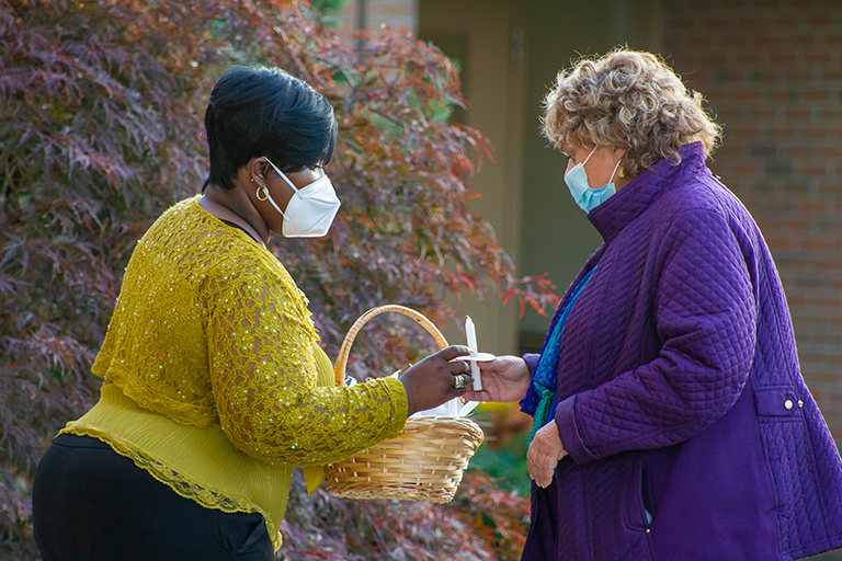 Tolethia Watts, activities assistant, left, and Darlene Malis-Delaelsche, director of nursing, take part in the candle lighting at Rivergate Terrace.