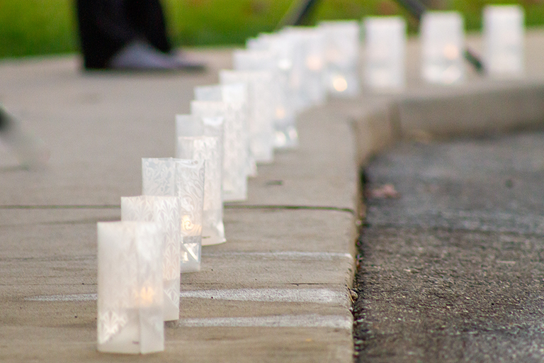 Luminaries line the sidewalk in honor of the 20 residents who passed away from COVID-19 at Rivergate Health Care Center.