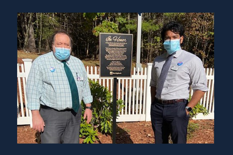 Wayne Nasiatka, director of nursing, left, with Carlos Bonilla, executive director, and the plaque