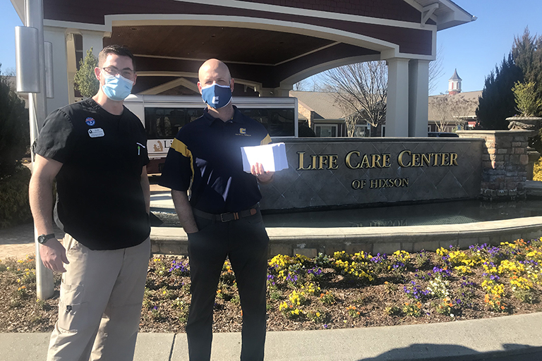 Josh Haislip, director of rehab (left), receiving letters from Matthew Grubb, assistant professor