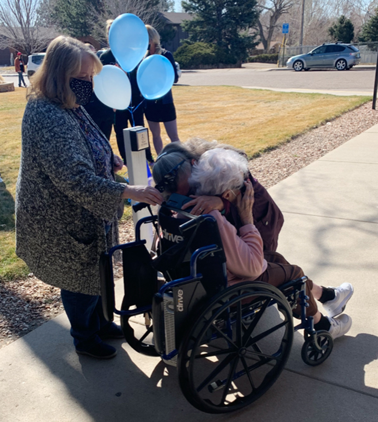 Resident Faye Cable hugs her daughter-in-law with her daughter, Gloria Webb, behind her.