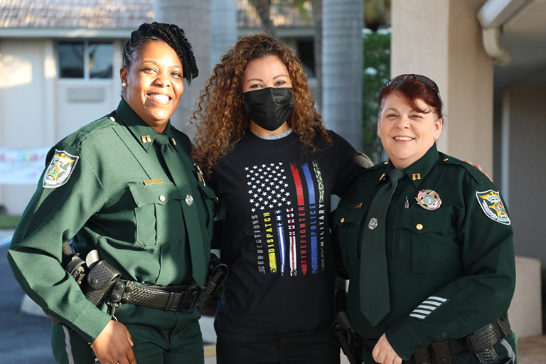 Elizabeth Brust, executive director, center, with two of Charlotte County’s heroes