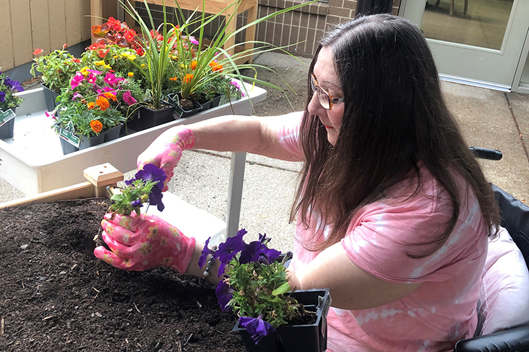 Mayfair Village resident Carol Stone planting flowers