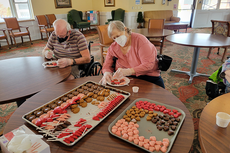 Life Care Center of Medina residents Dennis Skitzki and Davey Smith decorating chocolates