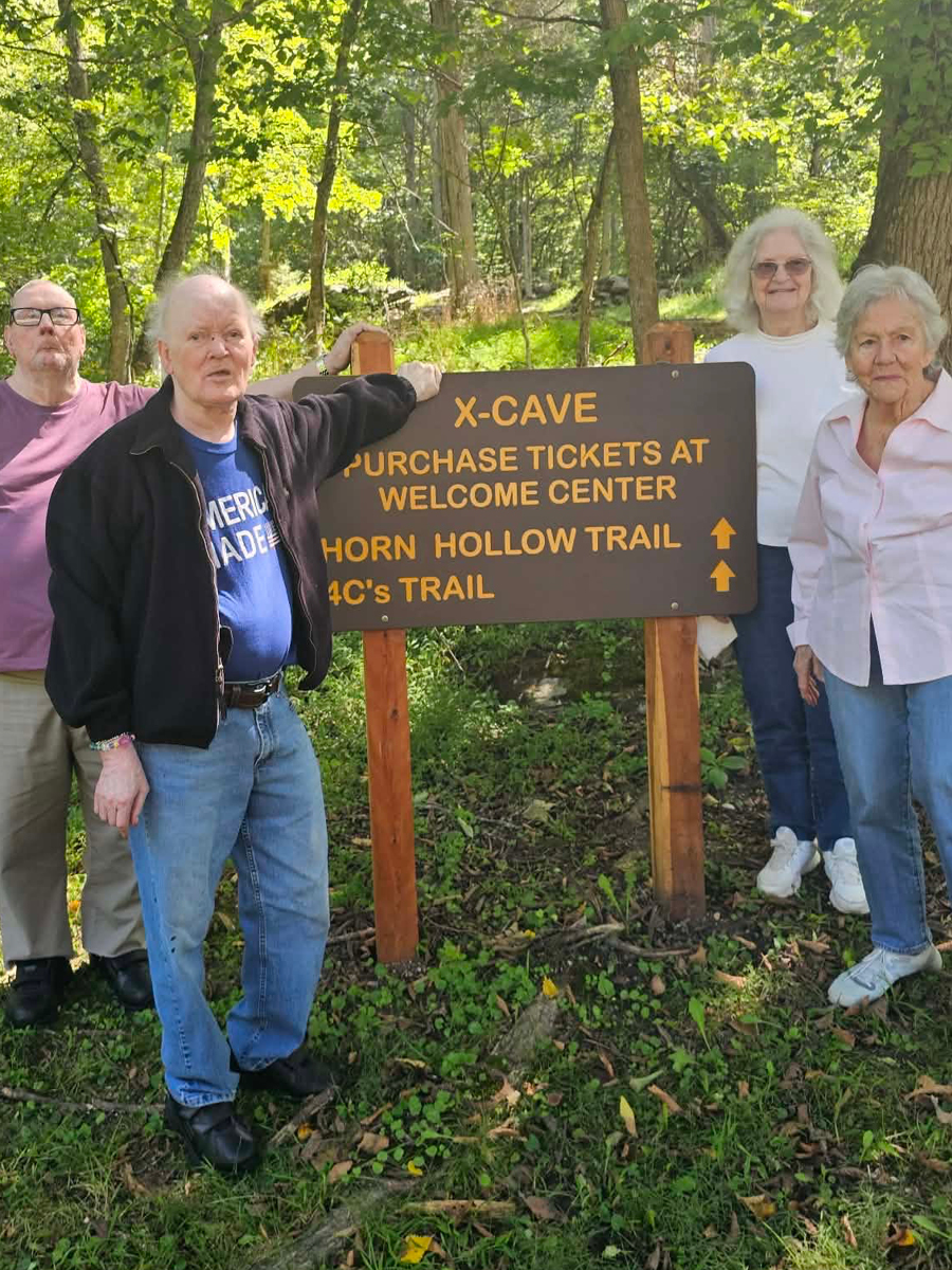 Carter Caves.jpg Seniors standing around a sign surrounded by greenery